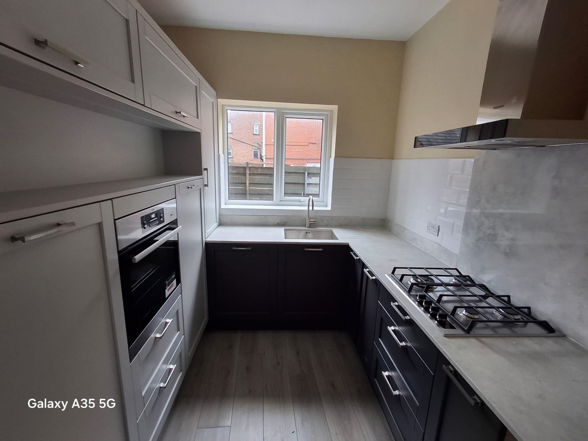 Cream shaker kitchen with marble worktops, central island and herringbone parquet wood floor