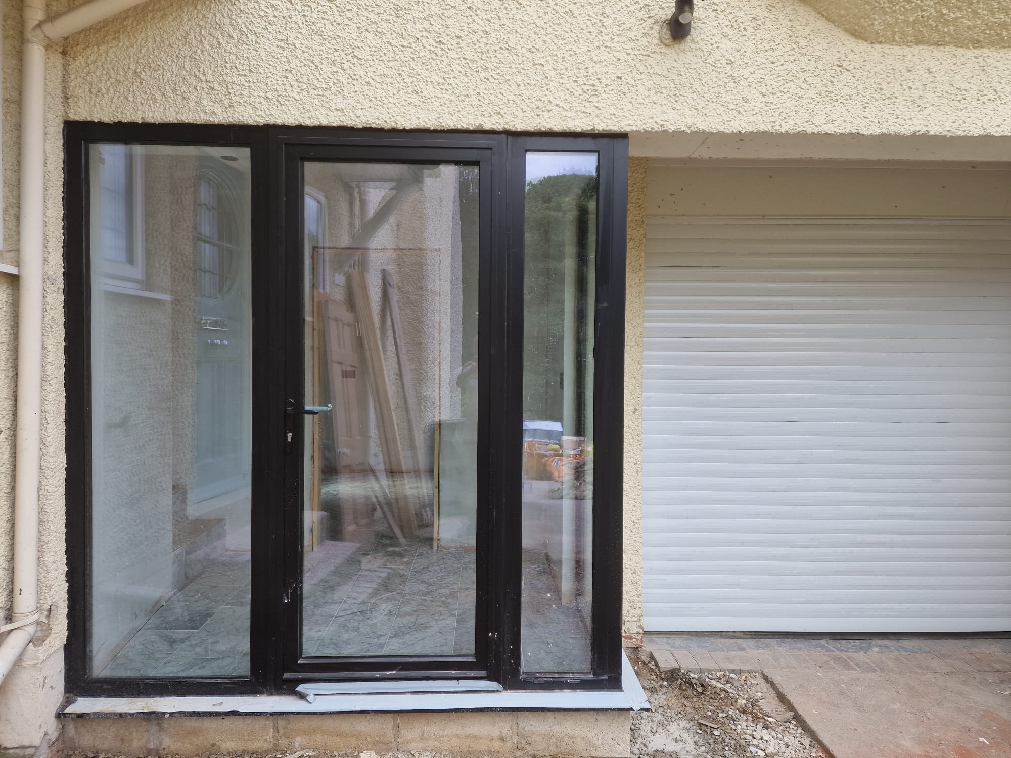 Large Indian sandstone garden patio laid to a Yorkshire family home with conservatory