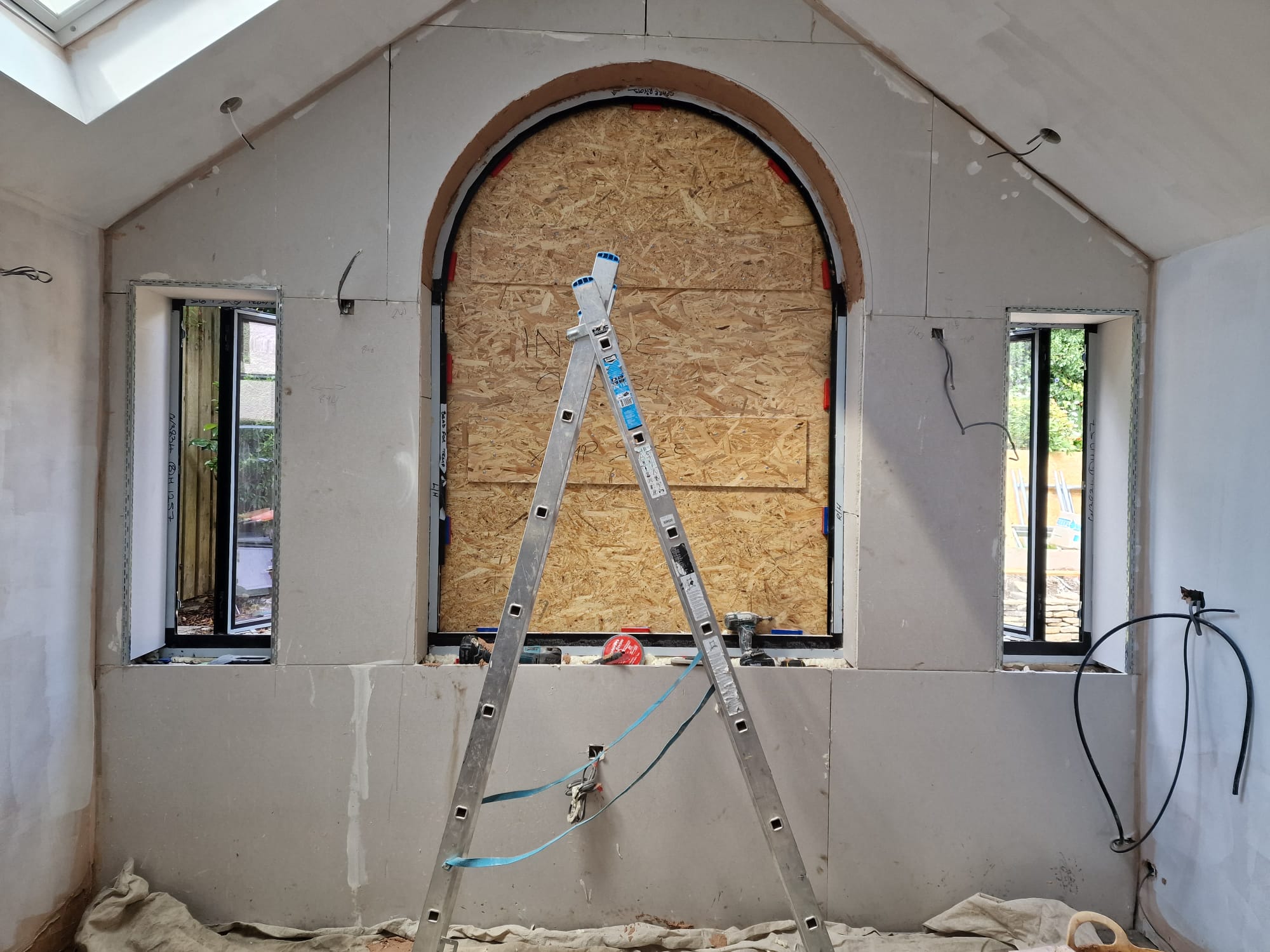 Newly built rear extension shell with bifold door opening on a render and brick Yorkshire home